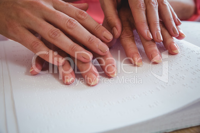 Nurse helping senior woman with braille