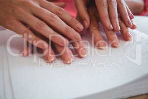 Nurse helping senior woman with braille