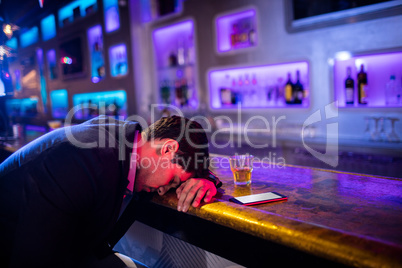 Depressed drunk man sleeping with his head on the table