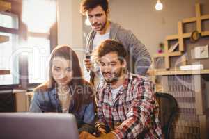 Graphic designer using laptop with his coworker