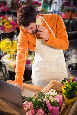 Male florist taking order on laptop Male florist taking order on laptop