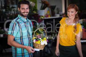 Female florist and customer with flower basket and visiting card