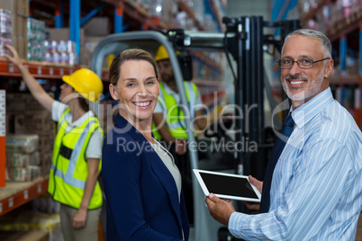 Business people are holding tablet and looking the camera