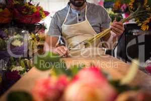 Male florist trimming flower stem