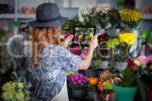 Female florist taking photograph of flowers