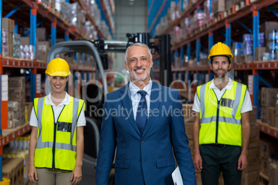 Focus of happy manager is posing in front of the workers