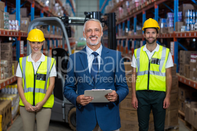 Focus of happy manager is posing in front of the workers