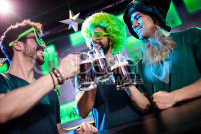 Male friends toasting beer mugs