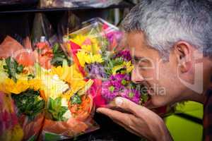 Male florist smelling flower