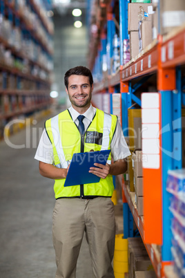 Worker with clipboard looking at camera