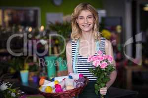 Female florist holding bunch of flower in flower shop