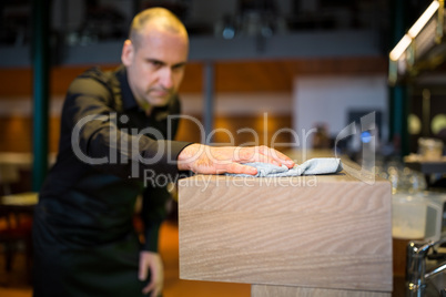 Bar tender cleaning bar counter