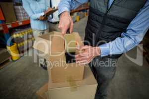 Close up of manager hands taping up a cardboard box