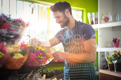 Male florist arranging bouquet of flower at flower shop