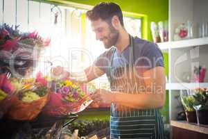 Male florist arranging bouquet of flower at flower shop