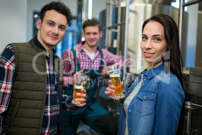 Brewers holding beer glasses at brewery factory