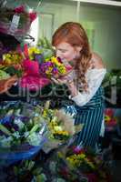 Female florist smelling flower bouquet