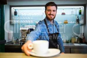 Waiter offering cup of coffee