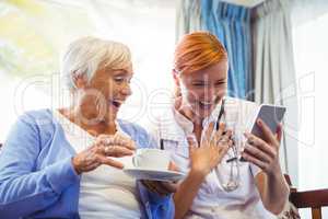 Senior woman and nurse using digital tablet