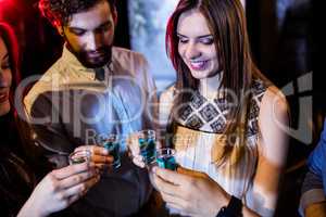 Group of friends toasting tequila shot glasses