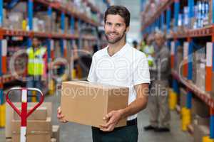 Portrait of worker is holding cardboard boxes and smiling to the