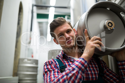 Portrait of brewer carrying keg