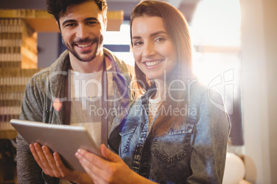 Portrait of graphic designer with his coworker looking at digita