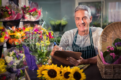 Male florist writing on clipboard