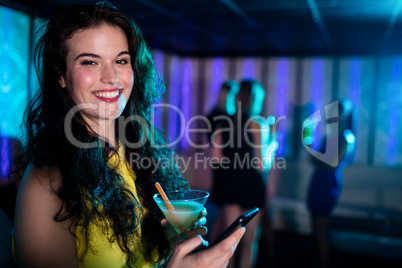 Beautiful woman using mobile phone while having cocktail Beautiful woman using mobile phone while having cocktail