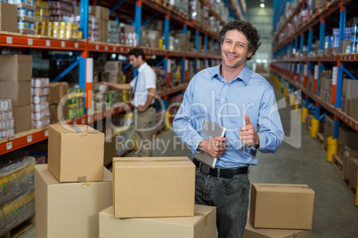 Portrait of happy manager posing in the middle of cardboard boxe