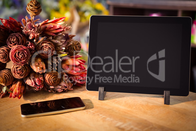 Bouquet of flower with smartphone and digital tablet on the wood