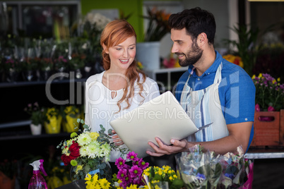 Man showing laptop to woman