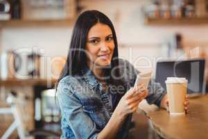 Woman using mobile phone at office cafeteria