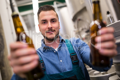 Brewer holding two beer bottle