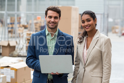 Portrait of happy managers are posing and smiling with a laptop