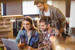 Graphic designer using laptop with his coworker