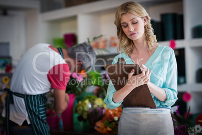 Female florist noting on clipboard