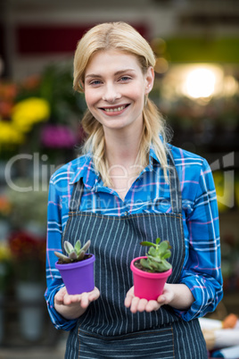Female florist holding plant pot in flower shop