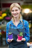 Female florist holding plant pot in flower shop