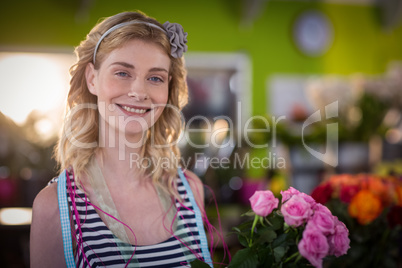 Female florist holding bunch of flowers