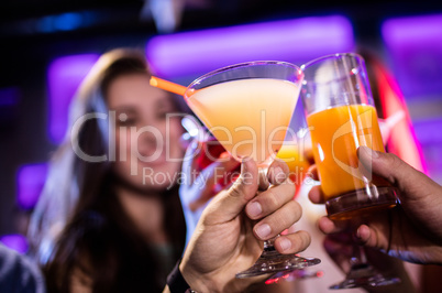 Friends toasting cocktail at bar counter