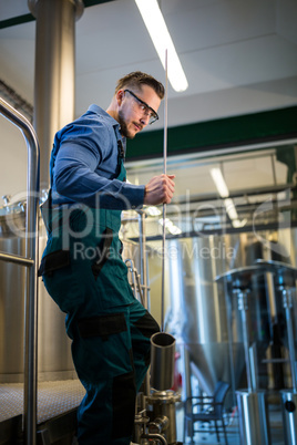 Thoughtful Brewer holding working equipment
