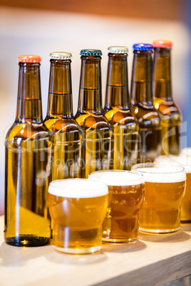 Arranged beer glasses and bottles on the bar counter