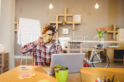 Portrait of graphic designer using laptop while having coffee