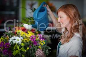 Female florist watering flowers