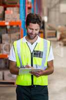 Portrait of worker is writing on clipboard