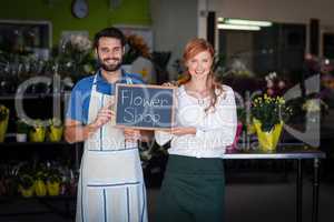 Couple holding slate with flower shop sign
