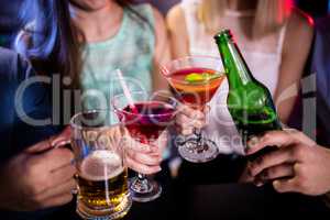 Group of friends toasting cocktail, beer bottle and beer glass a