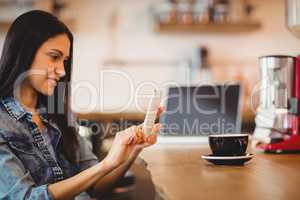 Woman using mobile phone at office cafeteria