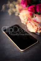 Pink roses and smartphone on the table